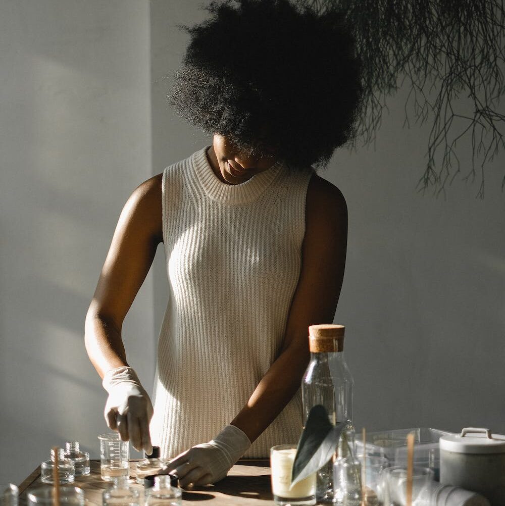 Femme à afro réalisant ses propres produits capillaires. 
